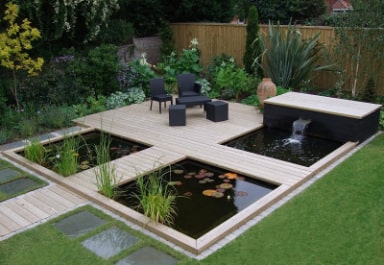 Narrow outdoor deck running beside a raised koi pond